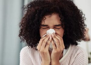 Woman Sneezing into Tissue