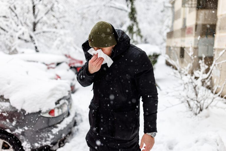 A Man with a Sinusitis is Using Facial Tissues During Cold Snowy Winter Day.