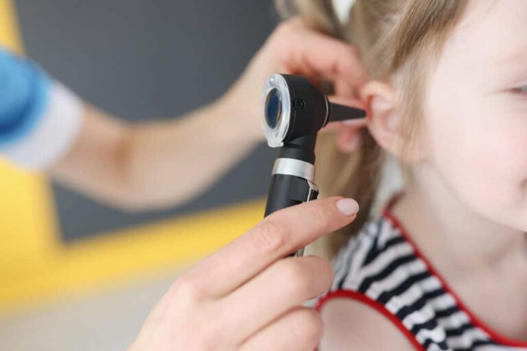 Doctor examining the ear of a little girl.