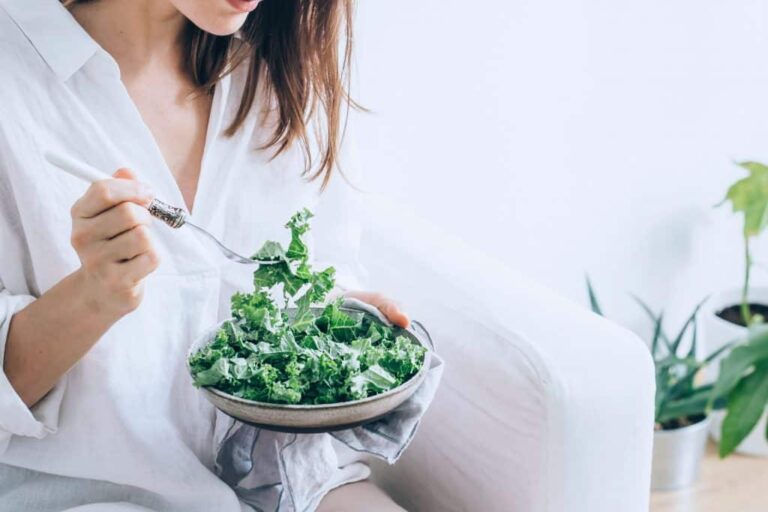 Woman eating a healthy kale salad.