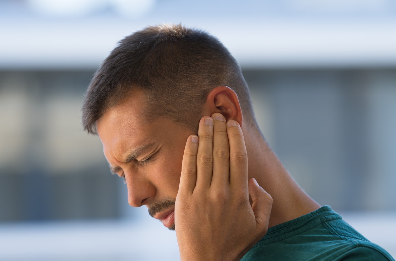 Man with earache holds ear