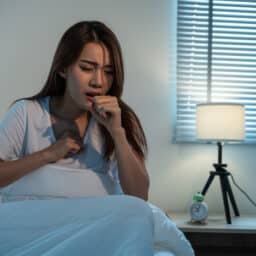 Woman coughing in bed at night