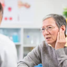 Man with earache speaks with doctor