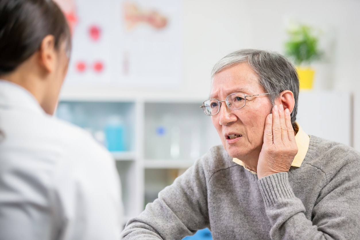 Man with earache speaks with doctor