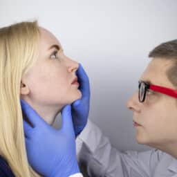 Doctor examines woman's nose