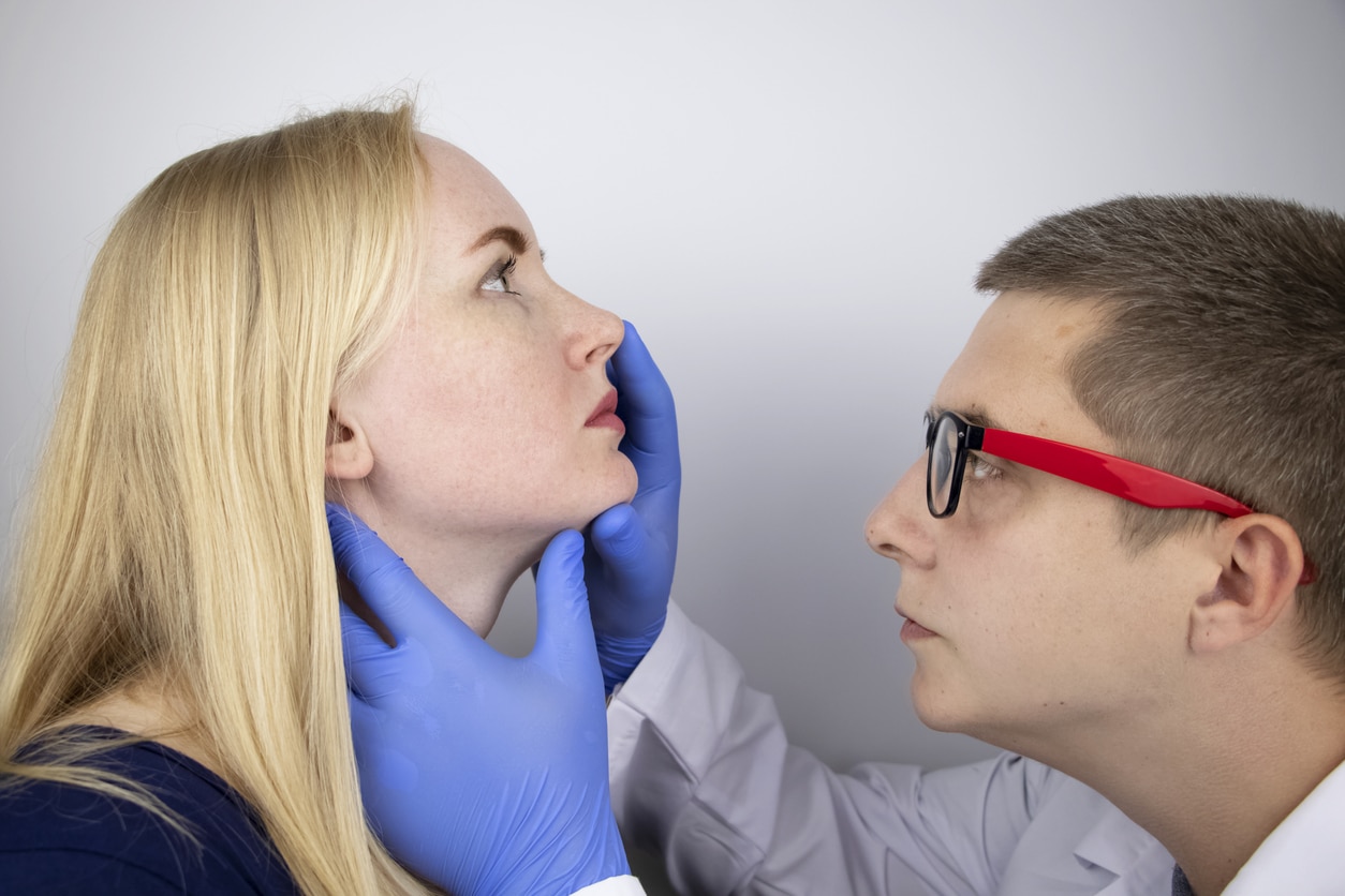 Doctor examines woman's nose