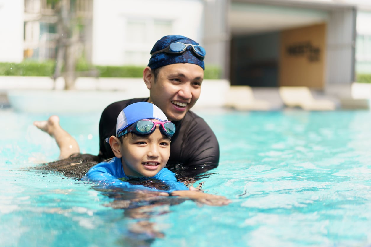 Father teaching his son to swim.