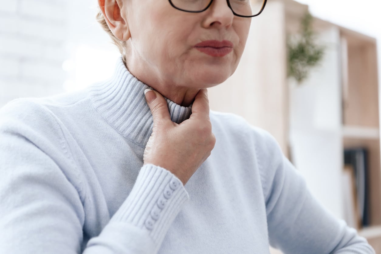 A woman holds neck