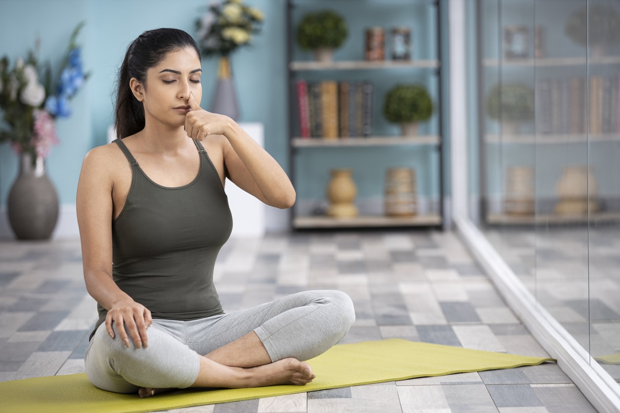 Woman on a yoga mat breathing through her nose.